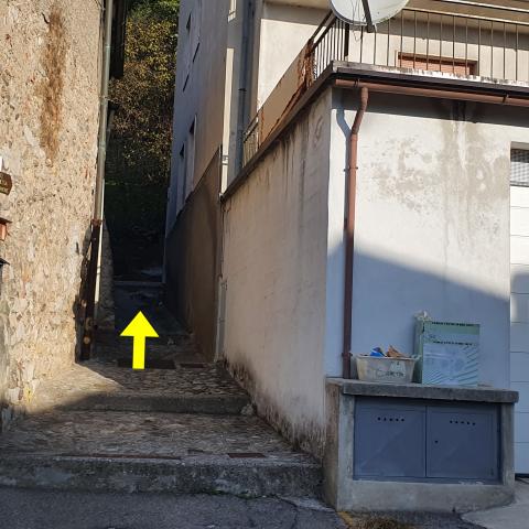 Foto nr. 6 imbocchiamo un sentiero a gradoni in cemento in ripida salita, chiuso tra due alti muri e contrassegnato da un cartello - © G.S. Marinelli, riproduzione vietata.